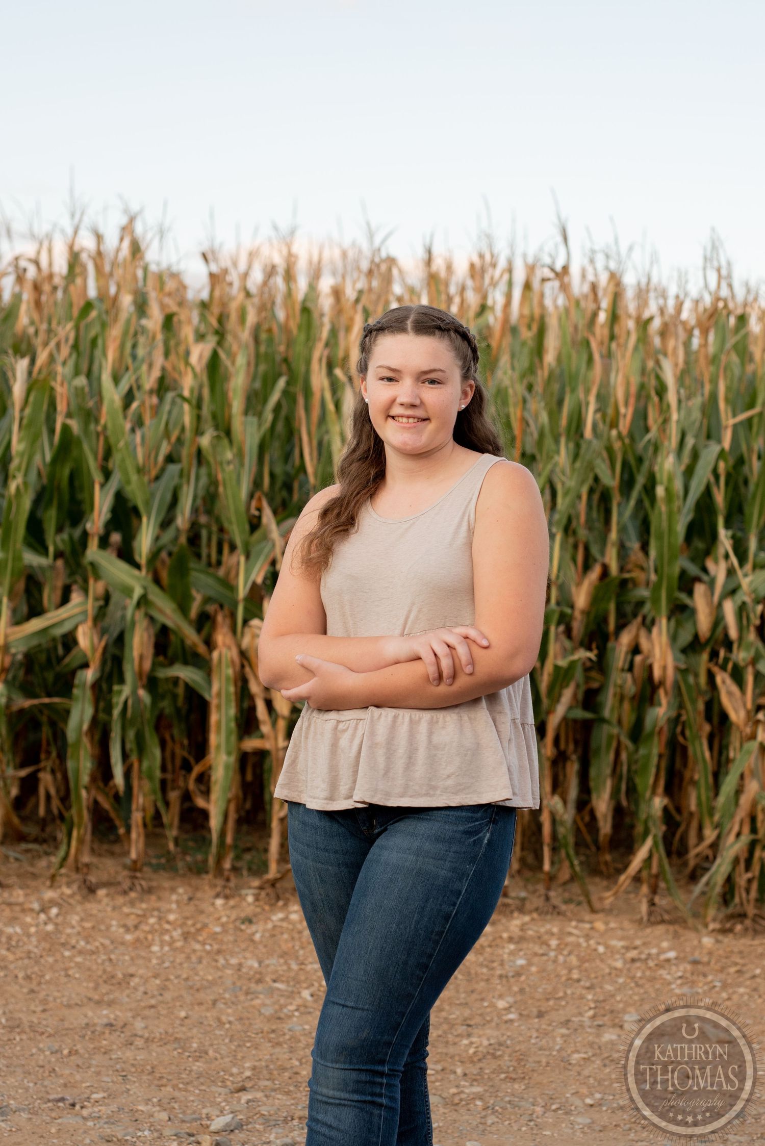 Portrait taken against a cornfield backdrop in casual attire during golden hour.