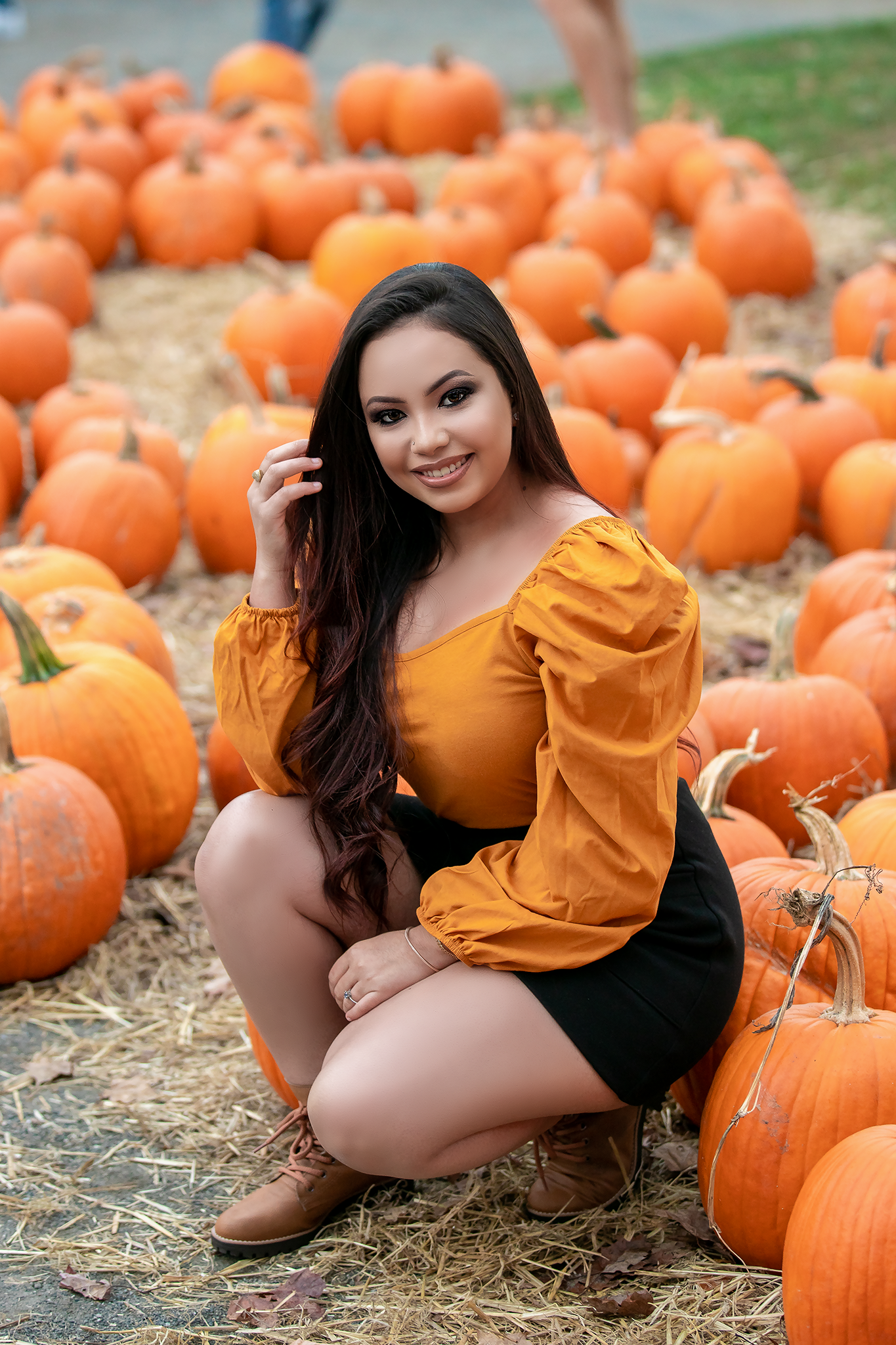 Autumn pumpkin patch setting with orange pumpkins scattered on hay.