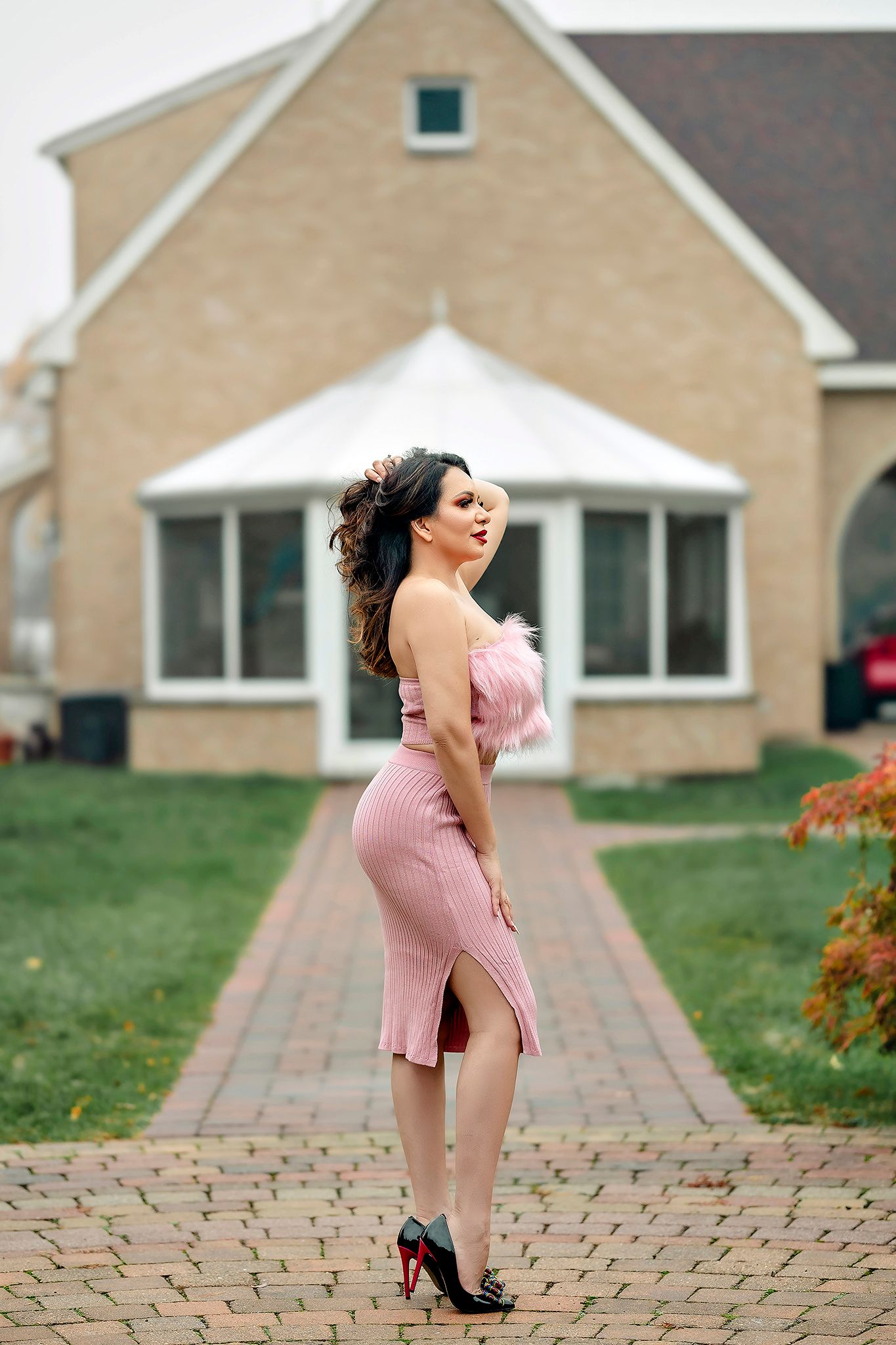 Fashion portrait series on brick pathway with pink outfit and heels.