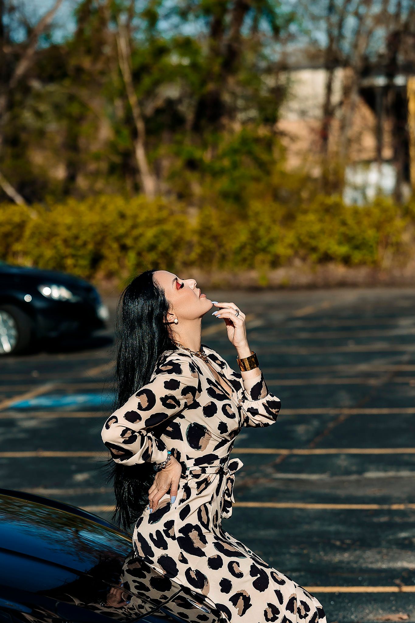 Dynamic poses in animal print dress against urban backdrop.
