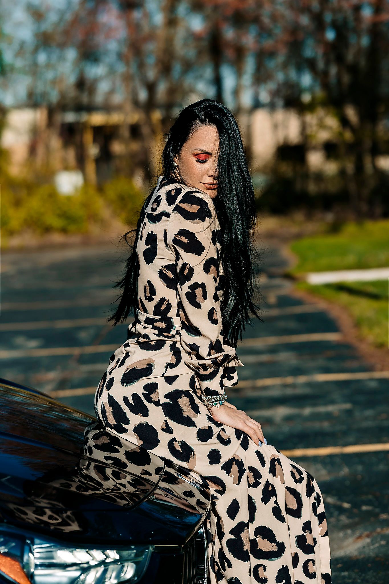 Stylish leopard print dress photo shoot in outdoor parking lot setting.