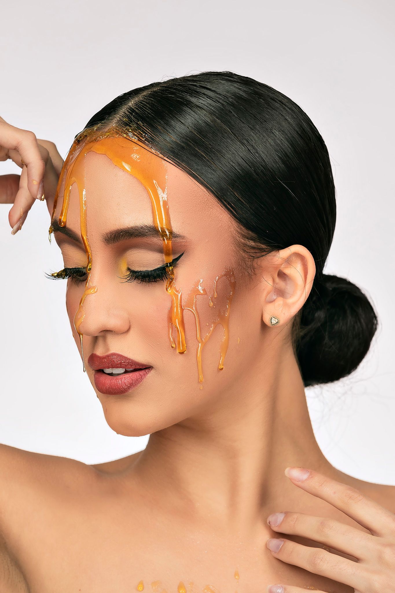 Beauty portrait featuring dripping honey effects and glamorous makeup in a creative beauty shoot.