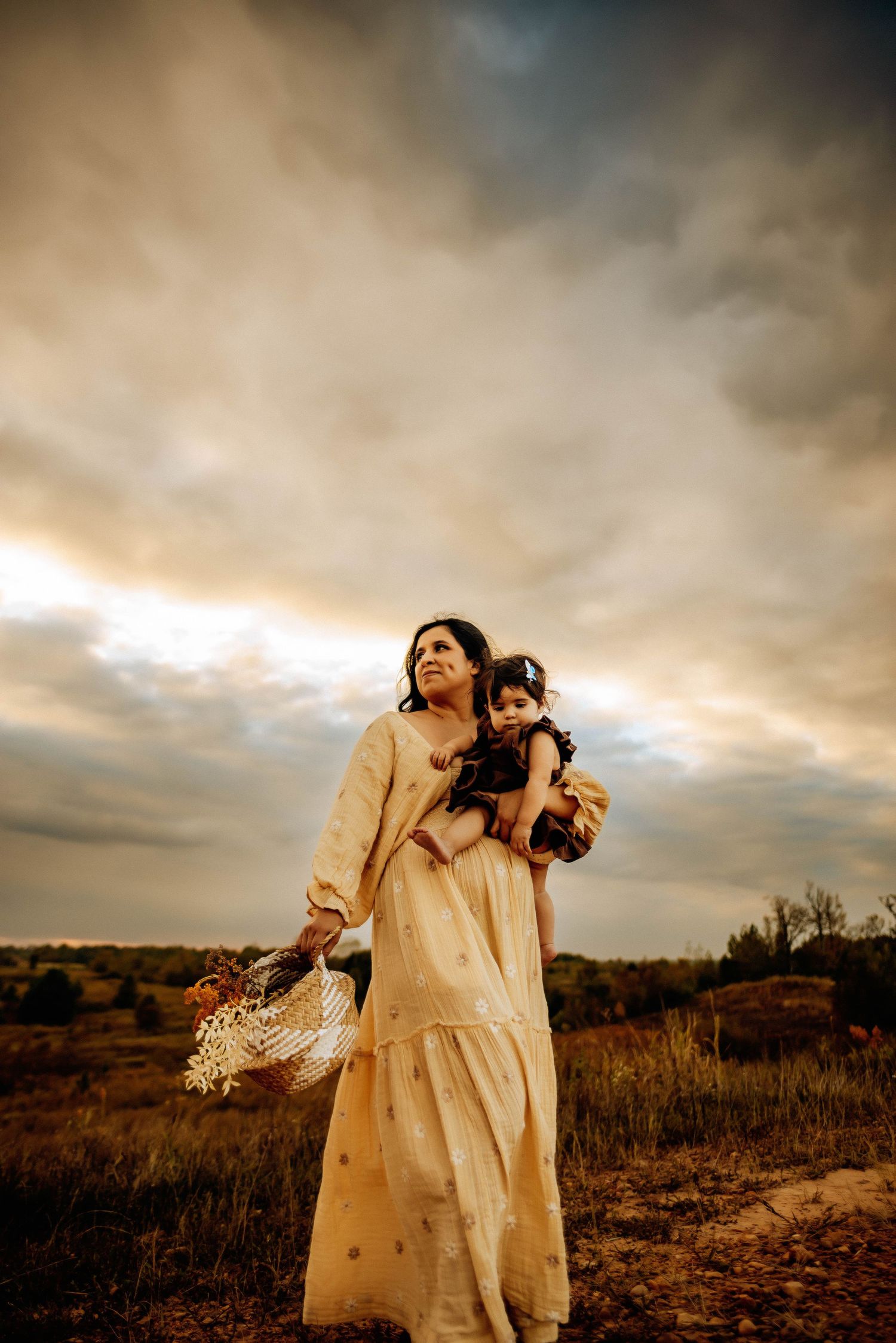 Ethereal portraits in cream dresses against moody storm clouds.