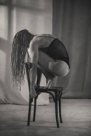 Minimalist black and white sequence showing graceful poses on chair.
