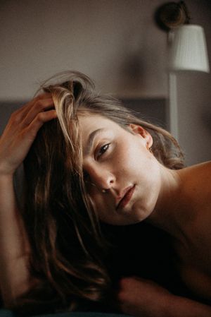 Moody boudoir photoshoot with dramatic lighting and shadows.