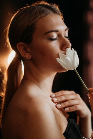 Close-up portrait series showing interaction with calla lily flower in warm lighting.