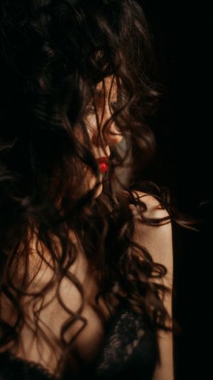 Intimate portrait with tousled hair and dramatic shadows.