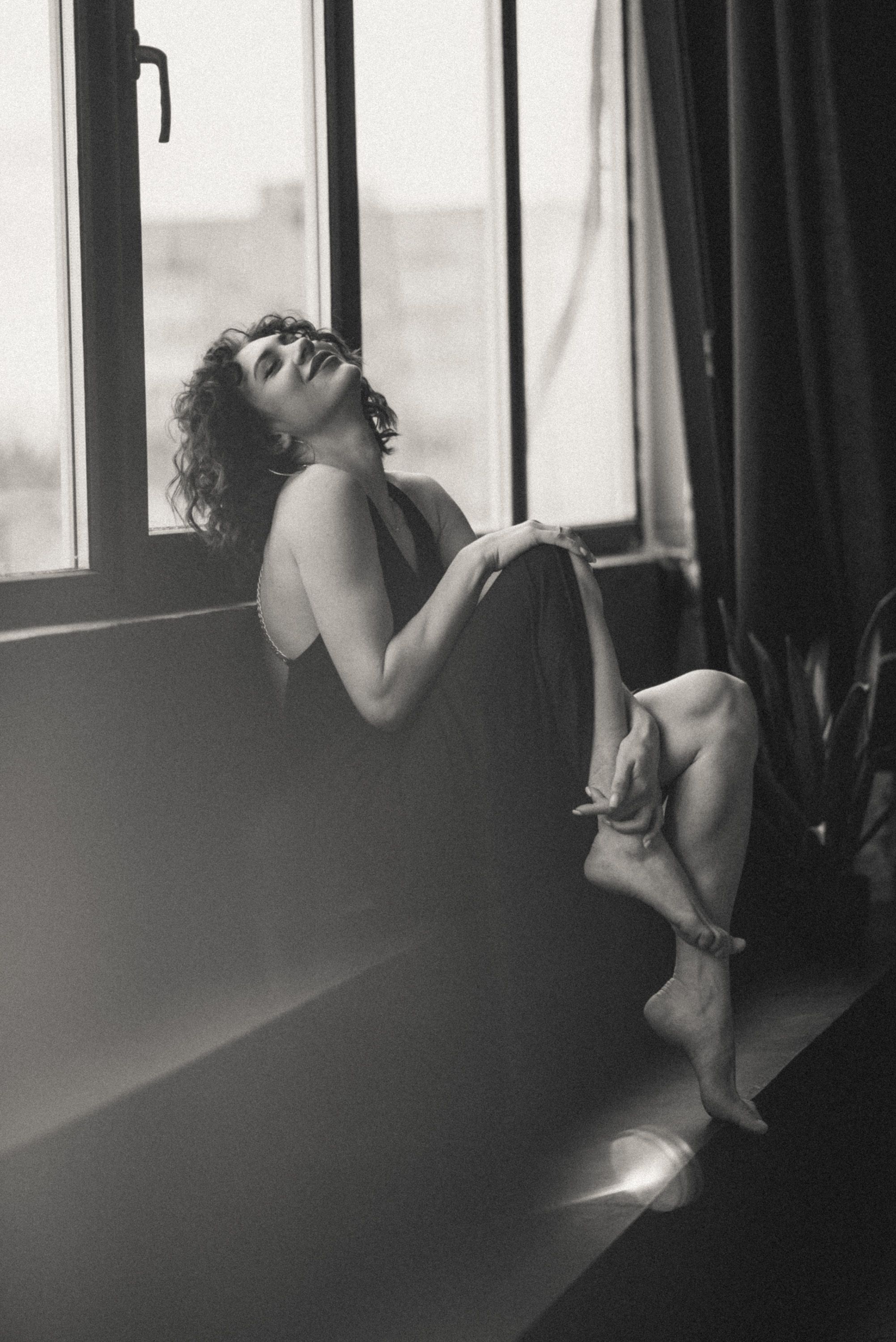 Artistic black and white photo series capturing emotional poses by window light.