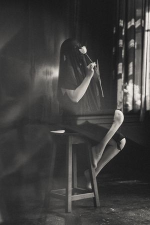Black and white artistic series showing movement and shadows near wooden chair.