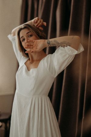 Joyful movement captured in a series of photos wearing a vintage-style white dress.