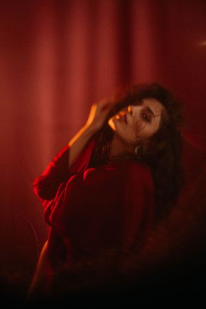 Moody portrait bathed in red light creating dramatic atmosphere.