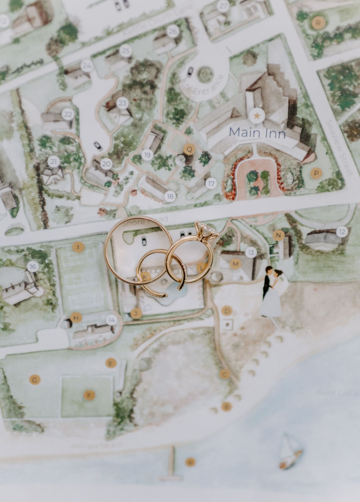 Wedding rings placed on a watercolor map illustration of venue grounds.