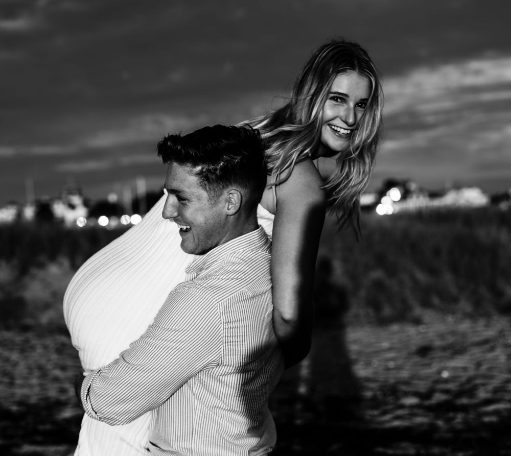 Black and white portraits capture tender moments between couple in natural setting.