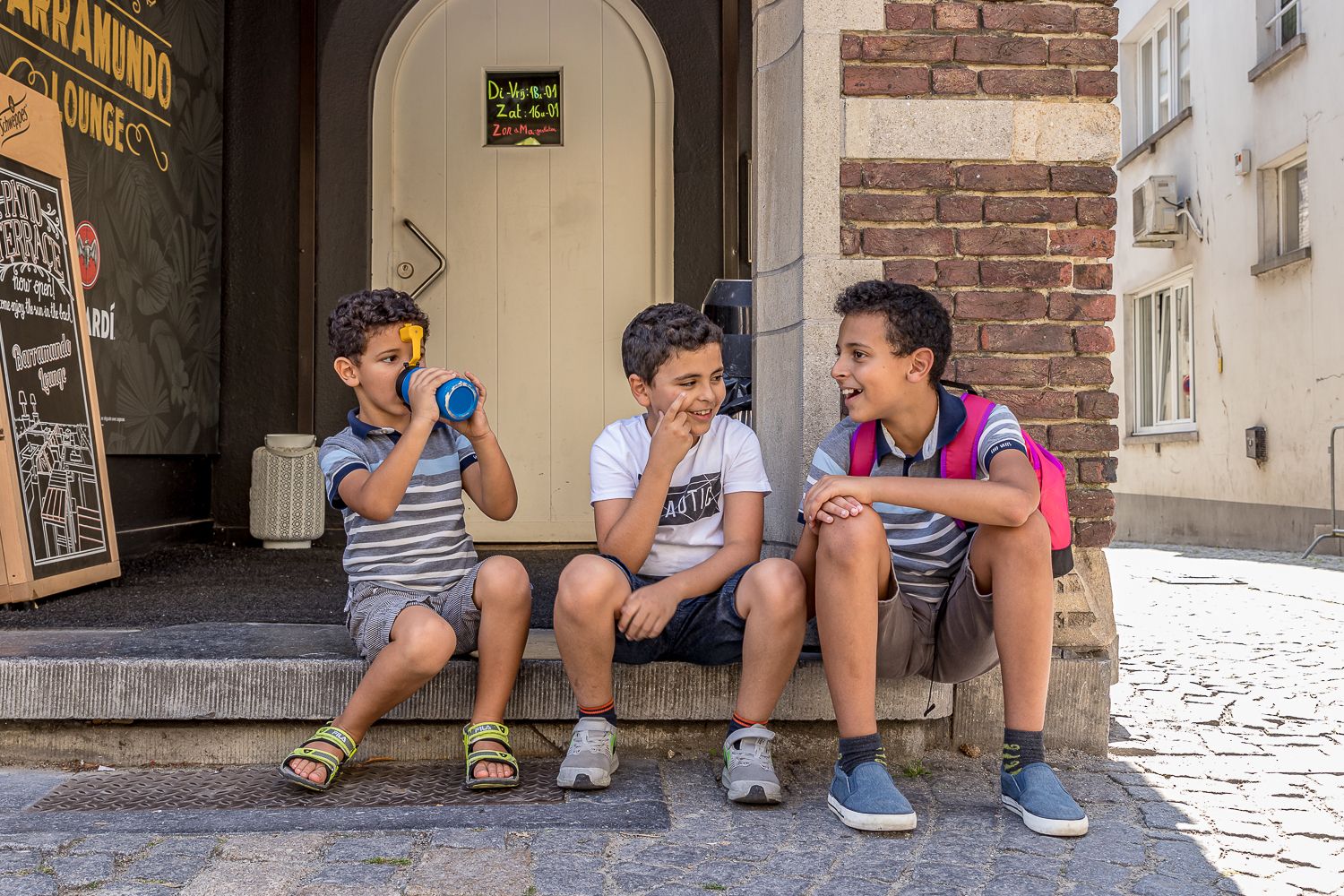 young boys sitting in front of doorstep talking and having fun