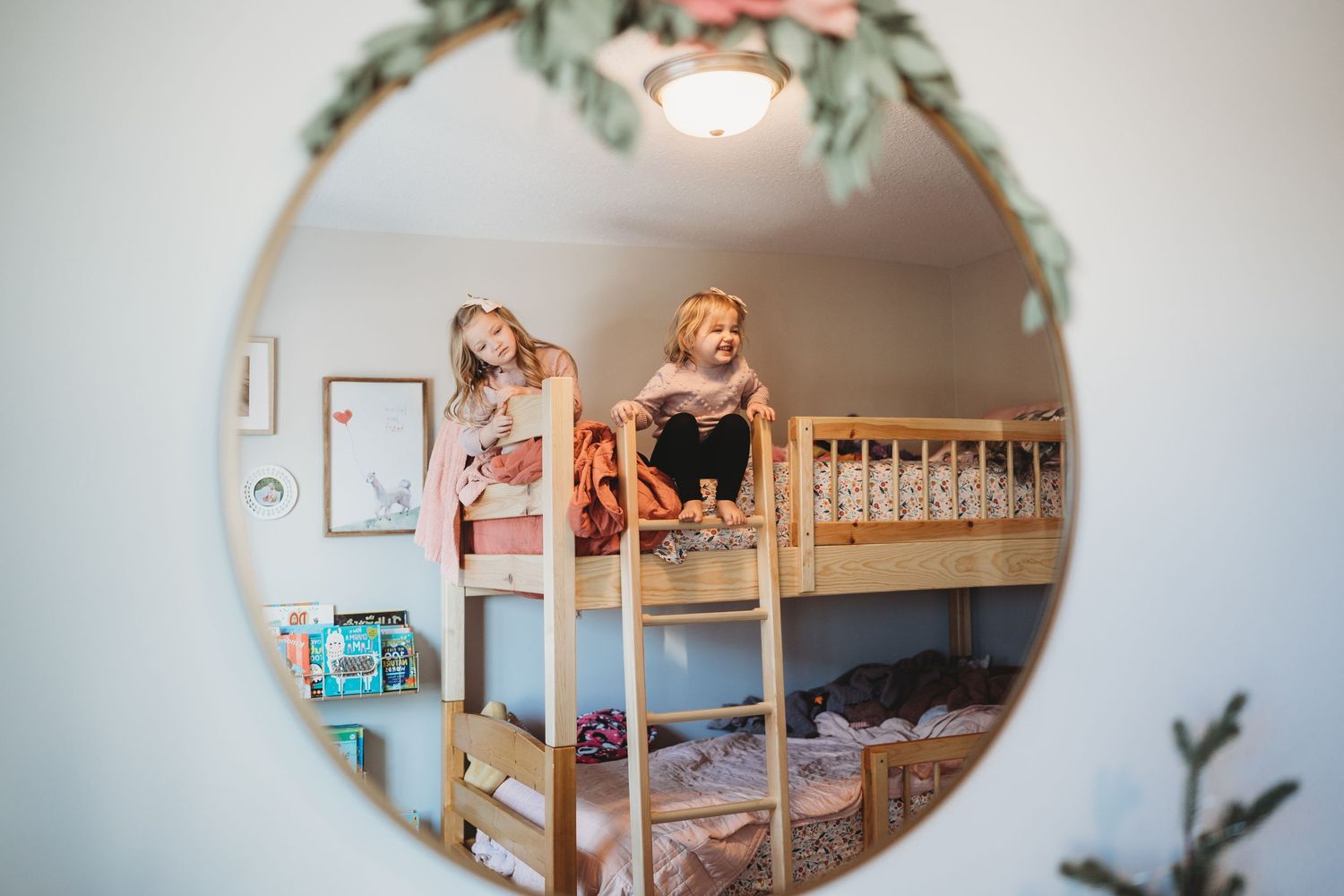 Decorative mirror and wall art hanging in a cozy bedroom with soft lighting.
