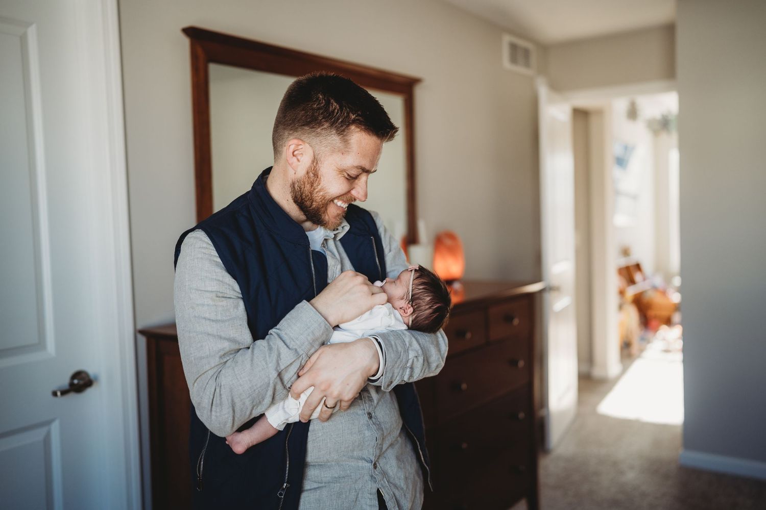 Intimate lifestyle photography session showing tender moments in a bright hallway.
