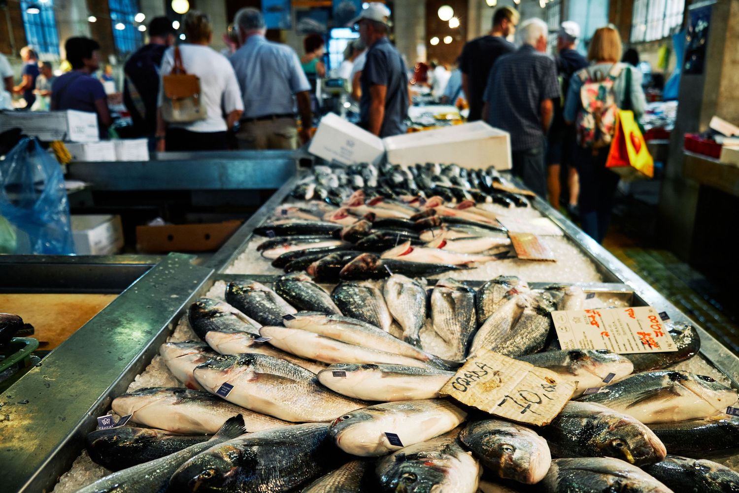 Fresh whole fish displayed on ice at a seafood market counter.
