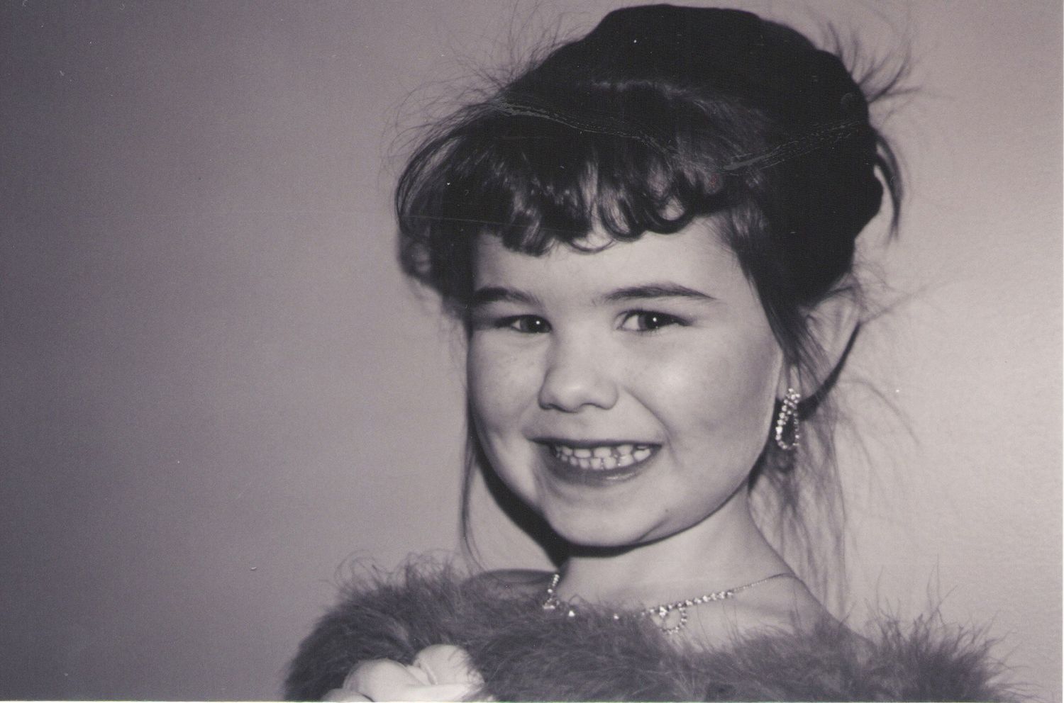 A vintage black and white portrait photograph showing a cheerful expression.