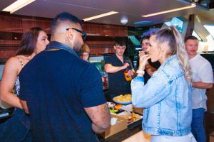 Casual gathering of people enjoying food and conversation at indoor party.
