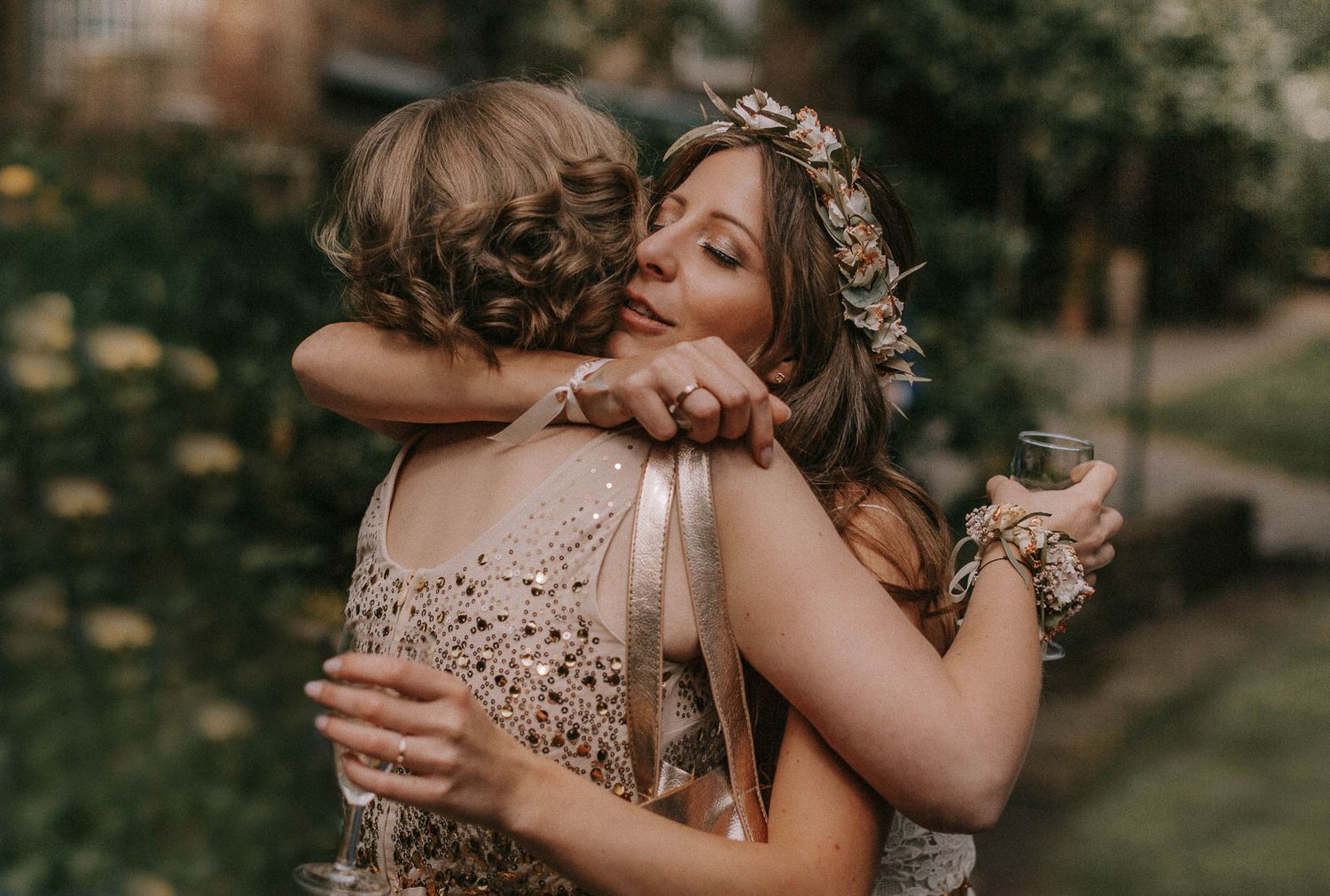Emotional embrace at outdoor wedding celebration with bokeh lights.