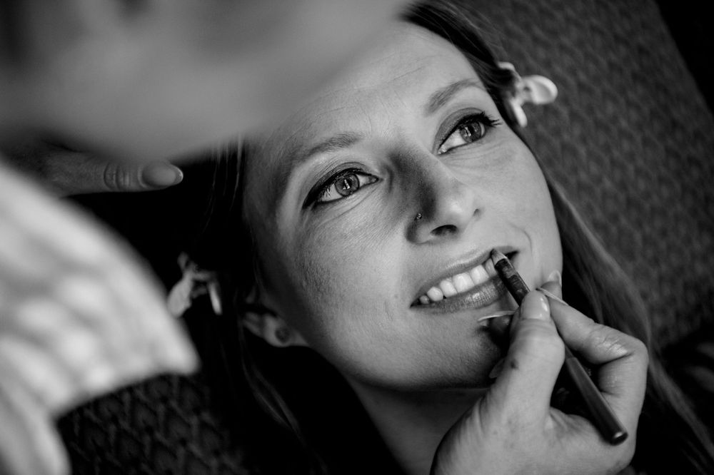Close-up black and white image showing makeup application during wedding preparations.