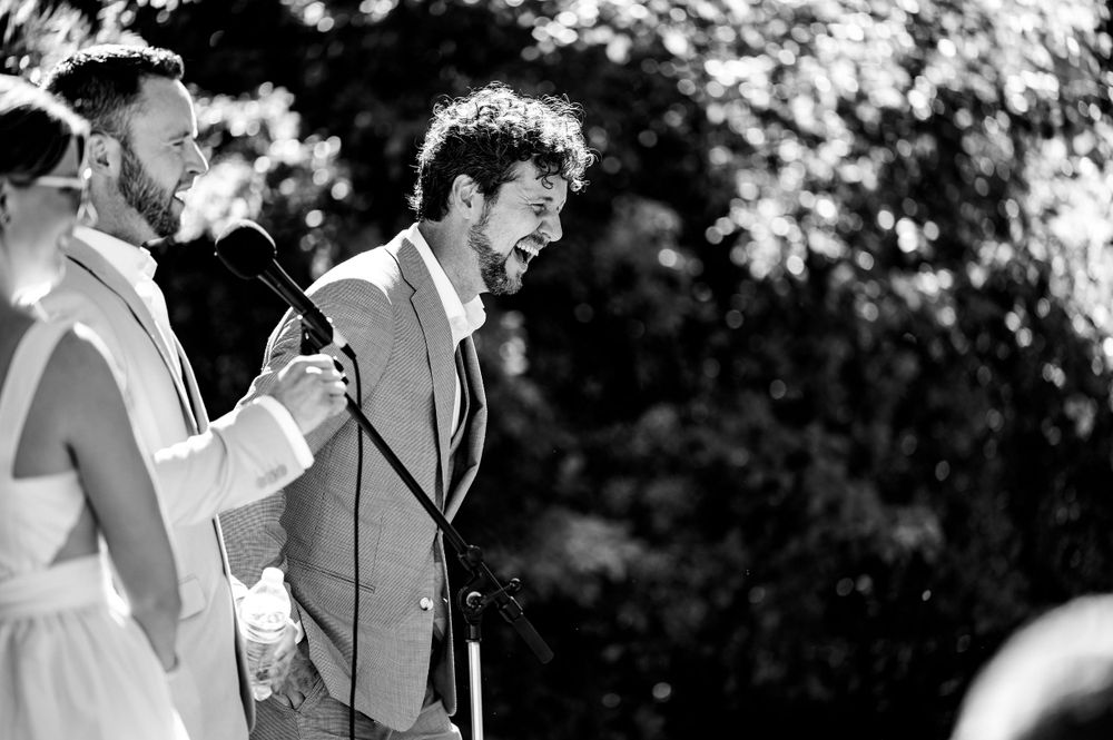 Black and white photo of an emotional exchange during wedding vows at an outdoor ceremony.