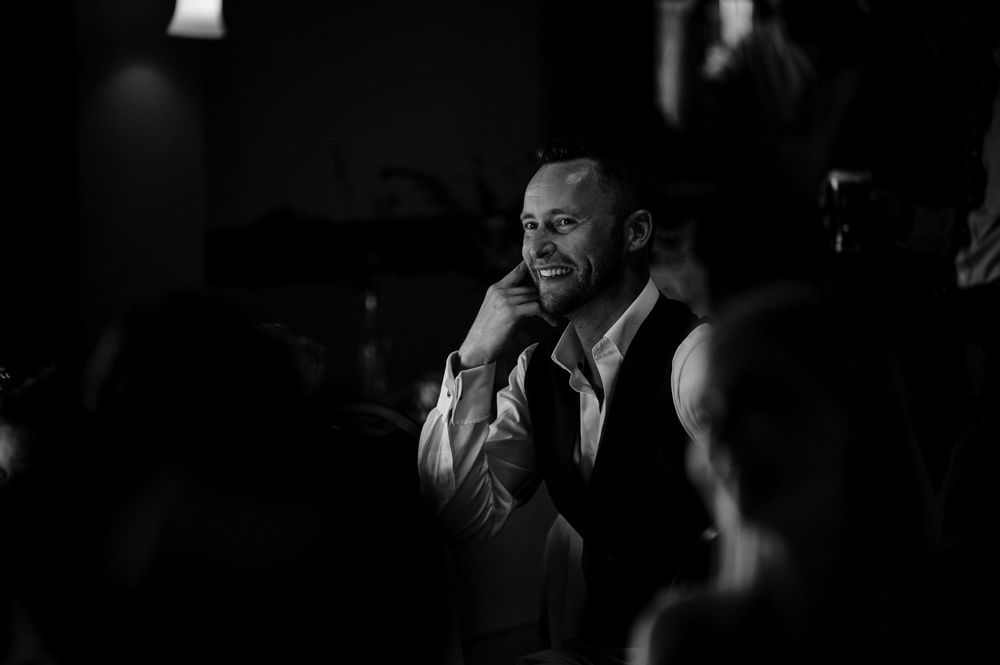 An entertainer performs at an event in dramatic black and white lighting.