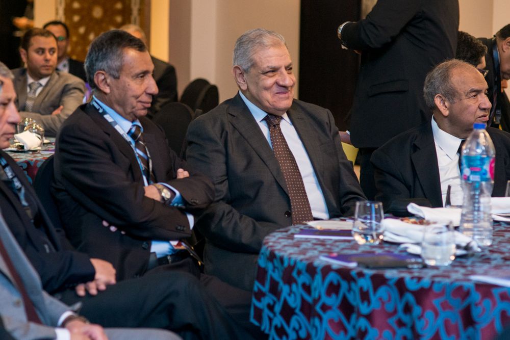 Business executives seated at conference table during formal corporate meeting.