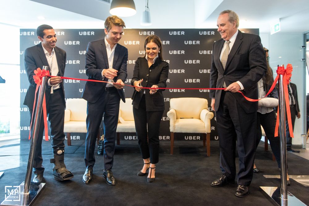 Ribbon cutting ceremony at Uber corporate event with executives.