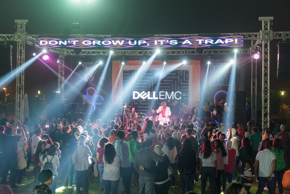 Concert crowd beneath neon sign reading Don't Grow Up It's A Trap at Dell EMC event.