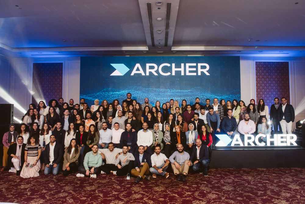 Large group photo of Archer team members posing together under company branding.