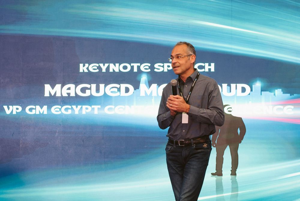 A keynote speaker presenting on stage at a corporate event with Archer branding.
