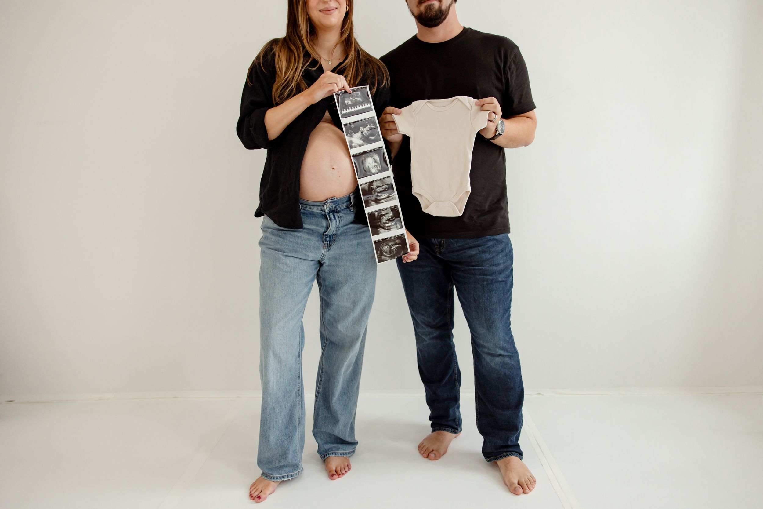 Casual couple posing and having fun with a retro boombox in a minimalist white studio.
