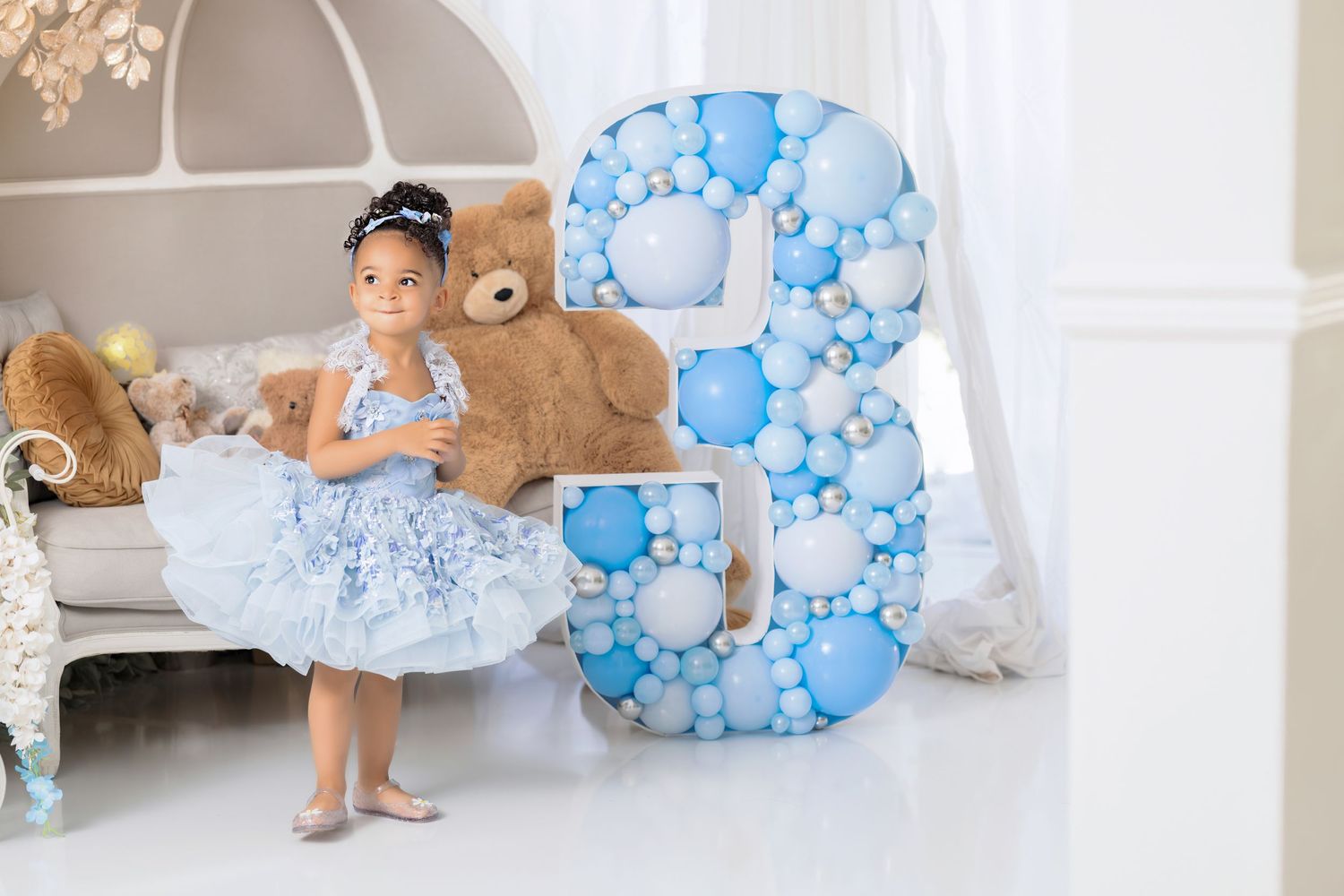 Dreamy birthday setup with blue balloon number 3 and tulle dress against a soft white background.