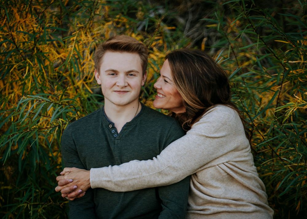 A tender moment shared between two people against a backdrop of golden fall foliage.