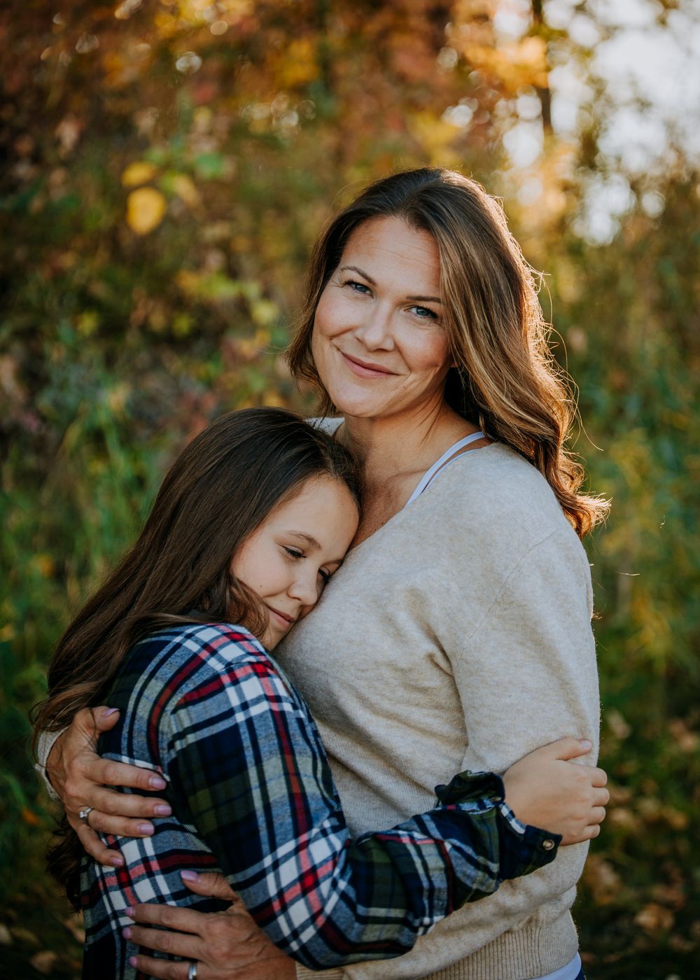 A heartwarming embrace shared between two people in an autumn setting with warm lighting.