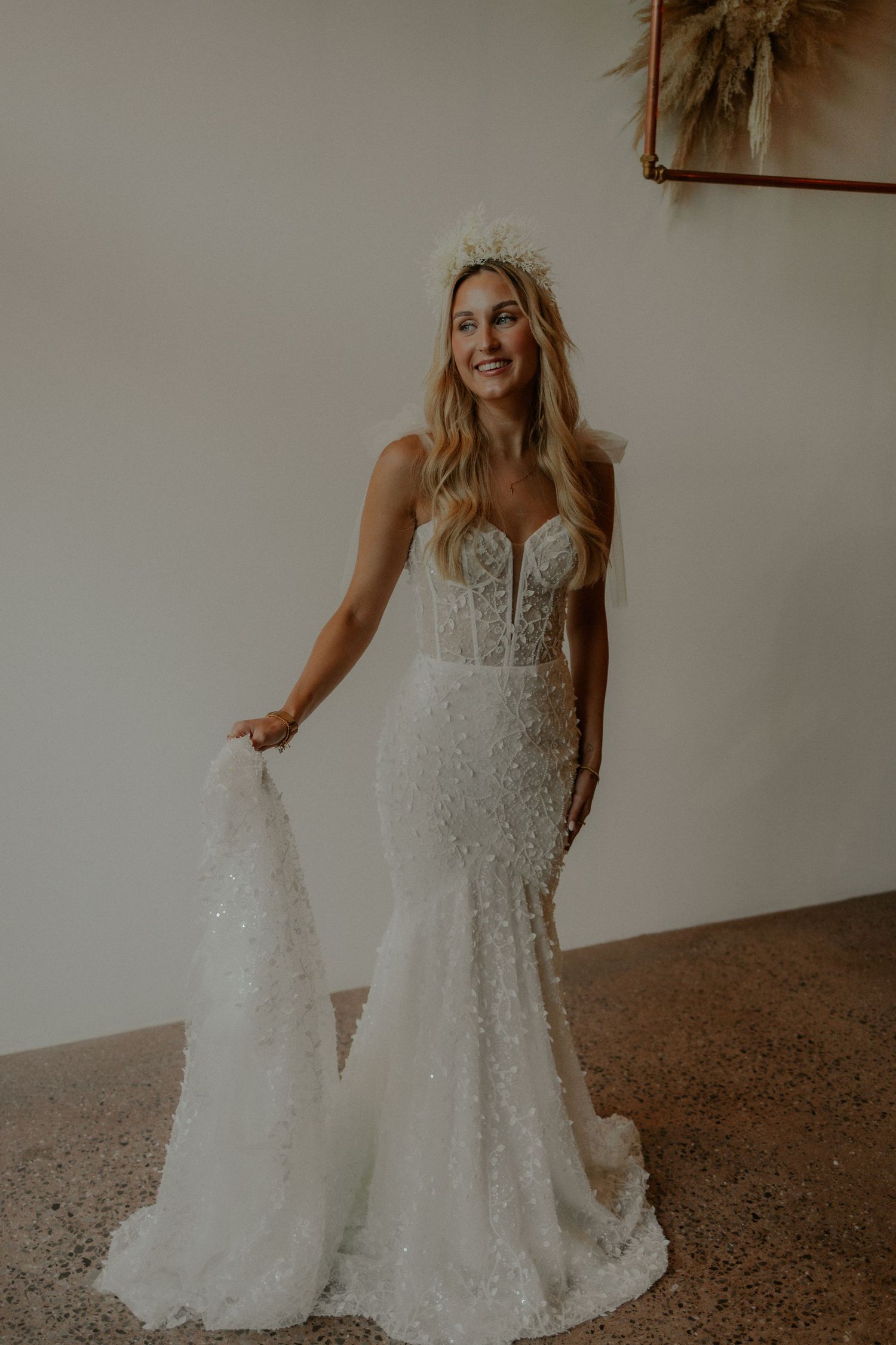 A fitted lace wedding gown with sweetheart neckline and sparkling sequin details trailing into a mermaid silhouette.