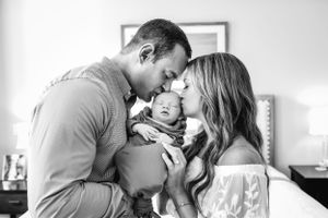 Couple holds and kisses their baby boy in Houston, TX.