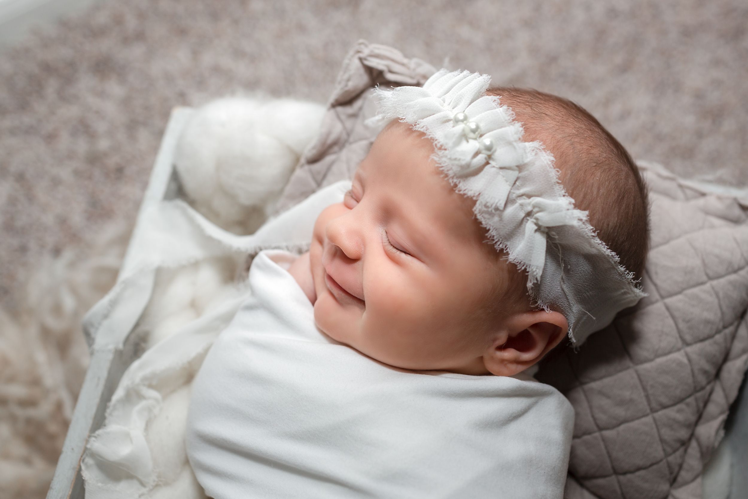 Newborn baby girl smiling during her lifestyle newborn session in Houston, TX.