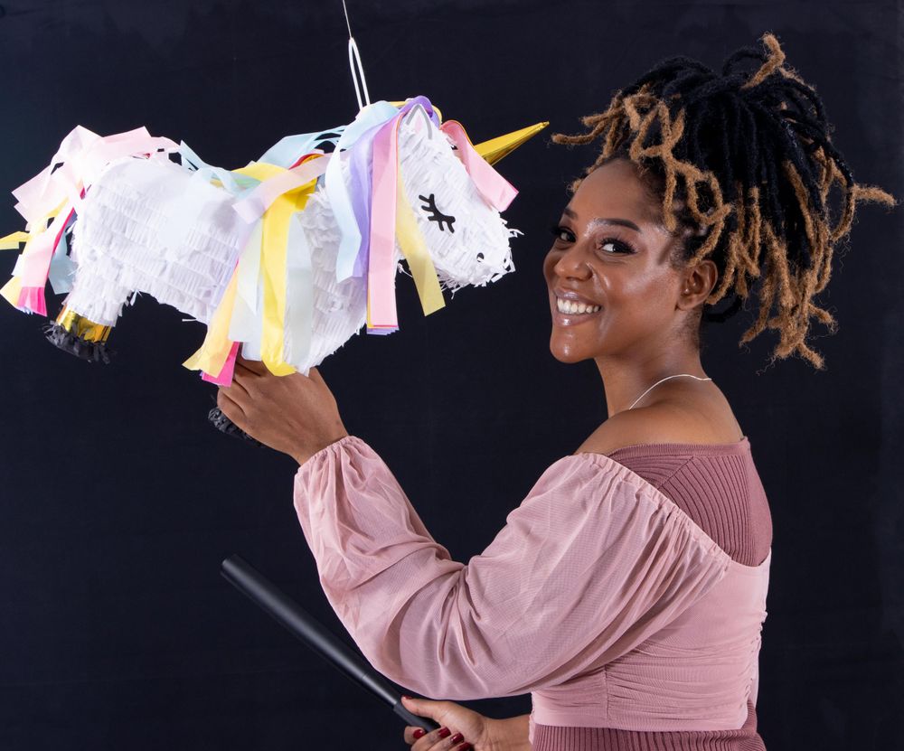 Happy moment captured while holding a colorful unicorn-themed party accessory.