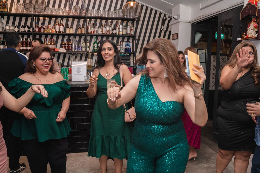 Friends in coordinated green outfits dancing and having fun at a party.