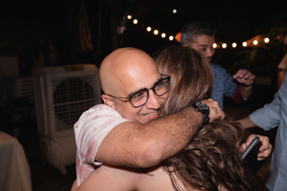 Emotional embrace shared during nighttime celebration with bokeh lights.
