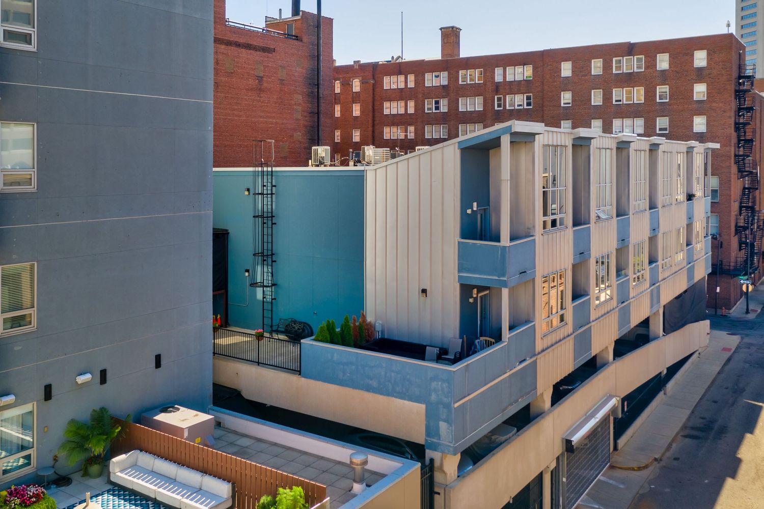 Modern urban apartment building in Columbus Ohio with blue and white exterior facade and multiple levels viewed from above.