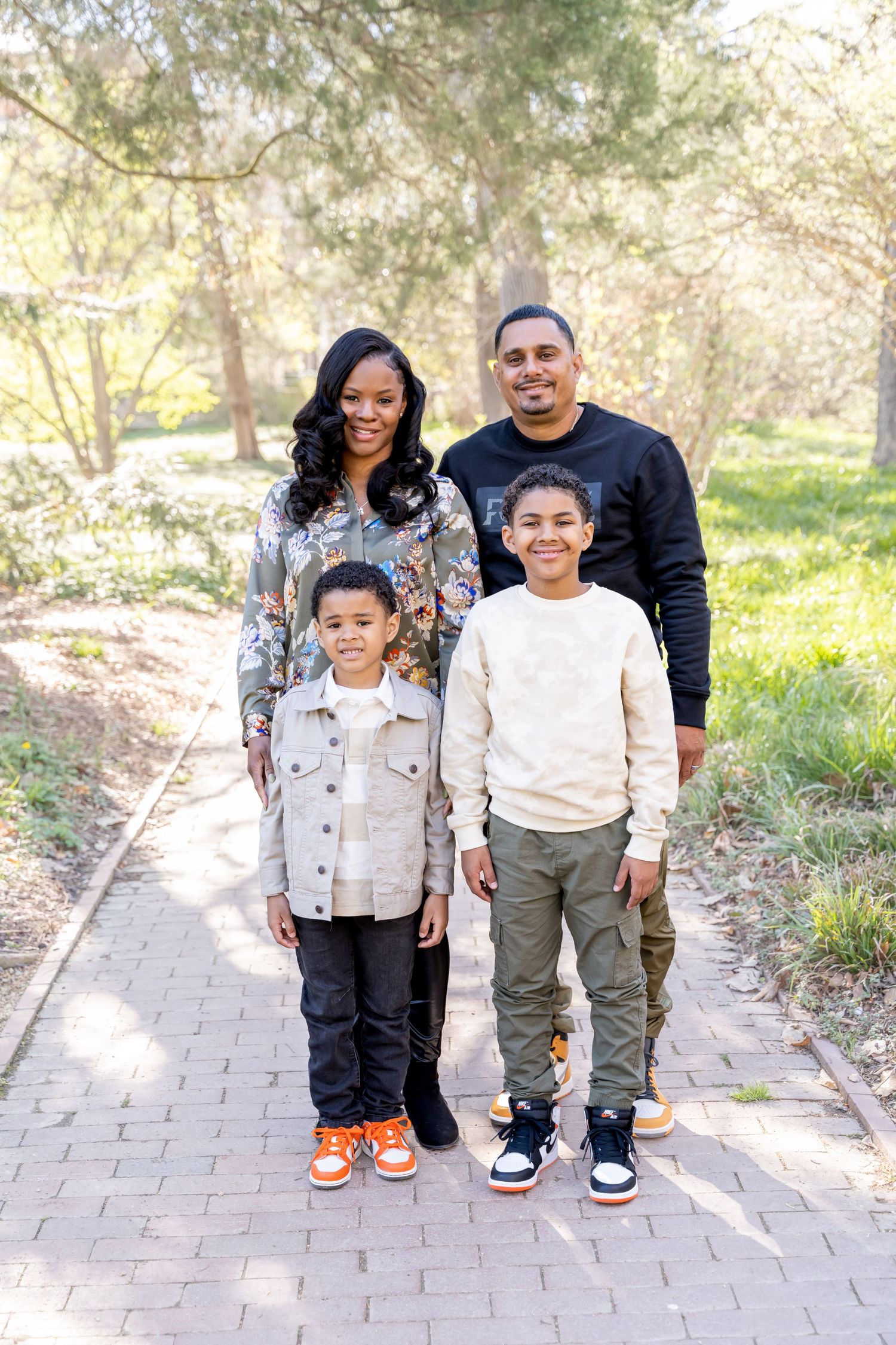 Family standing together for the family portraits at Coker Arboretum in Chapel Hill, NC