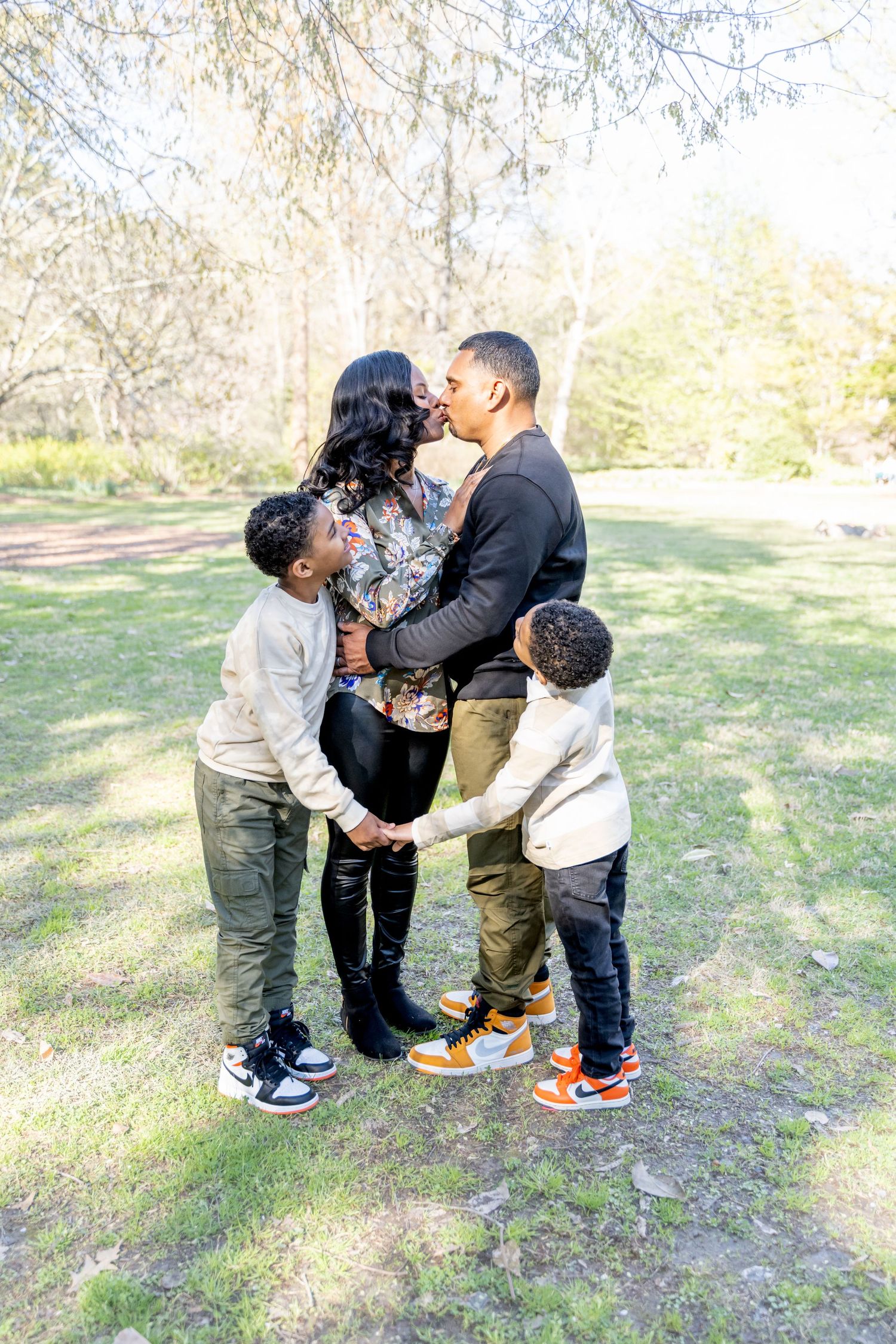 Mom and dad kissing while their kids watch and hold hands