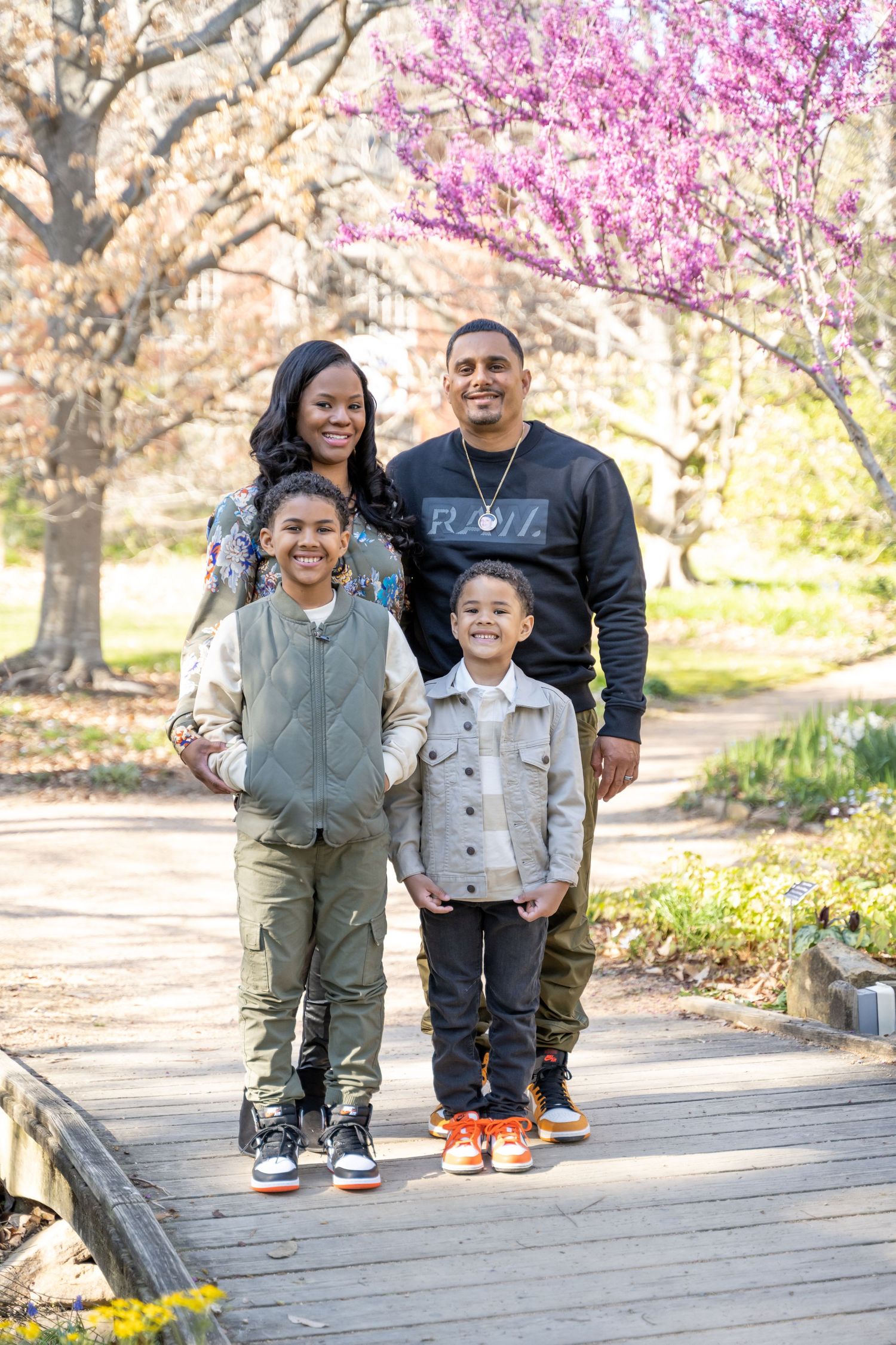 Family under a blossom tree at family portraits at Coker Arboretum in Chapel Hill, NC