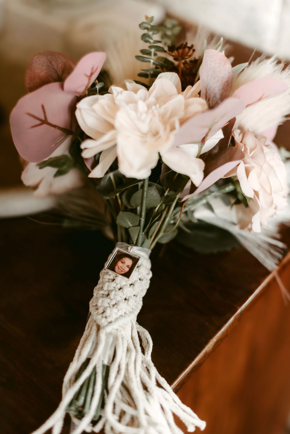 A delicate bridal bouquet with pink and white flowers wrapped in macrame.