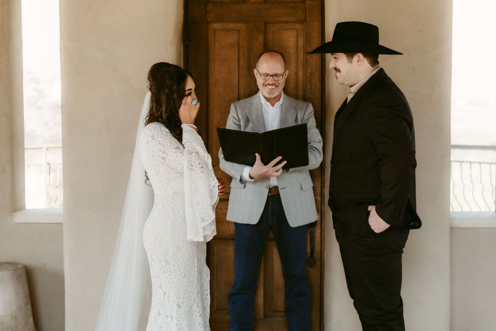Wedding ceremony in progress with officiant and couple in western attire.