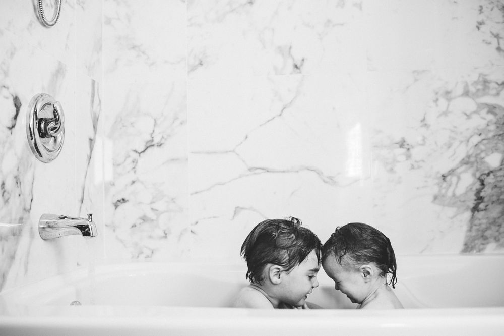 Black and white image of brother and sister in bath.