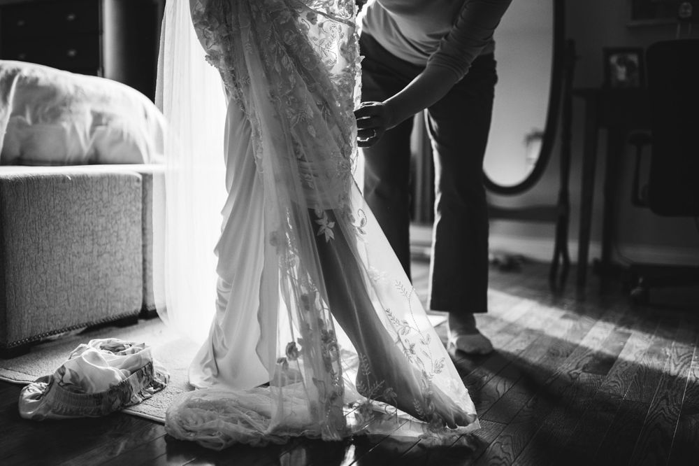 A womens leg slips into their wedding dress.
